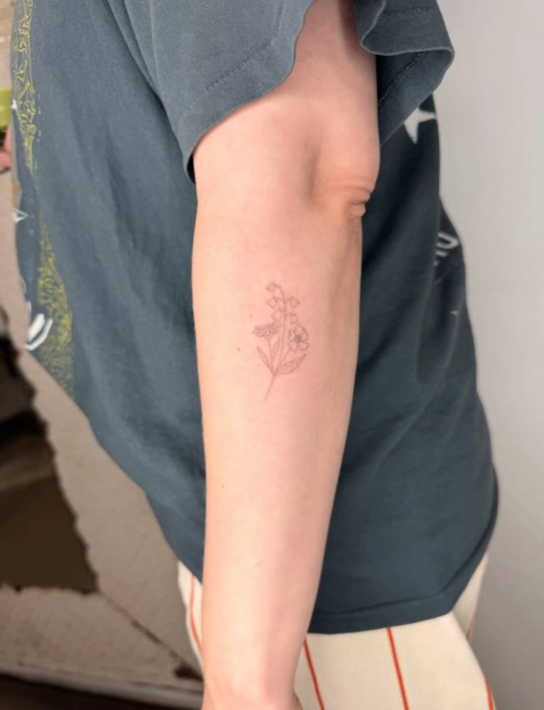 Flower bouquet tattoo in fine line located on the forearm.
