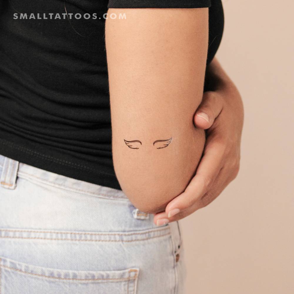 Small angel wings temporary tattoo located on the tricep.