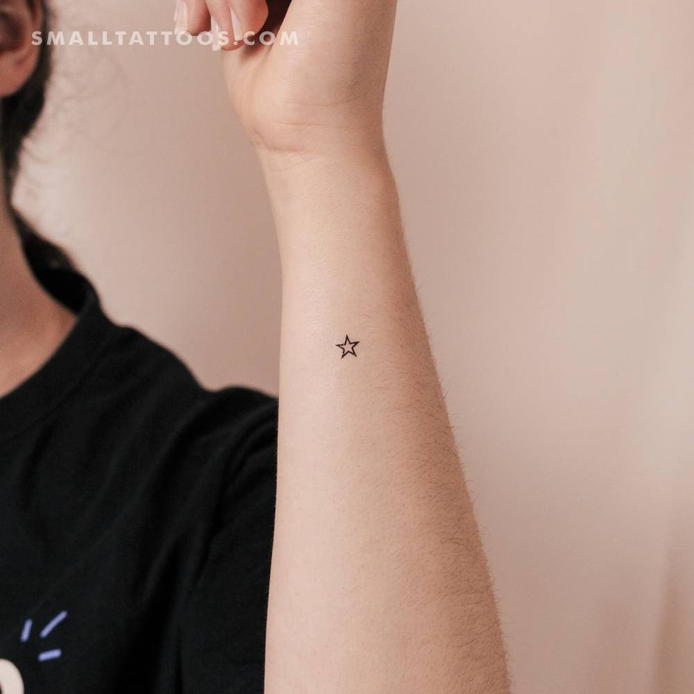 Minimalistic style small star outline temporary tattoo located on the wrist.