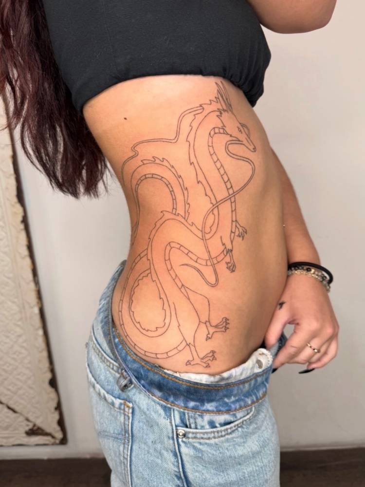 Fine line style Haku tattoo located on the side of the body.