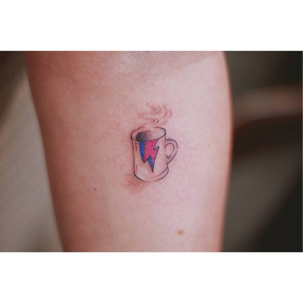 David Bowie bolt coffee mug tattooed on the inner forearm.