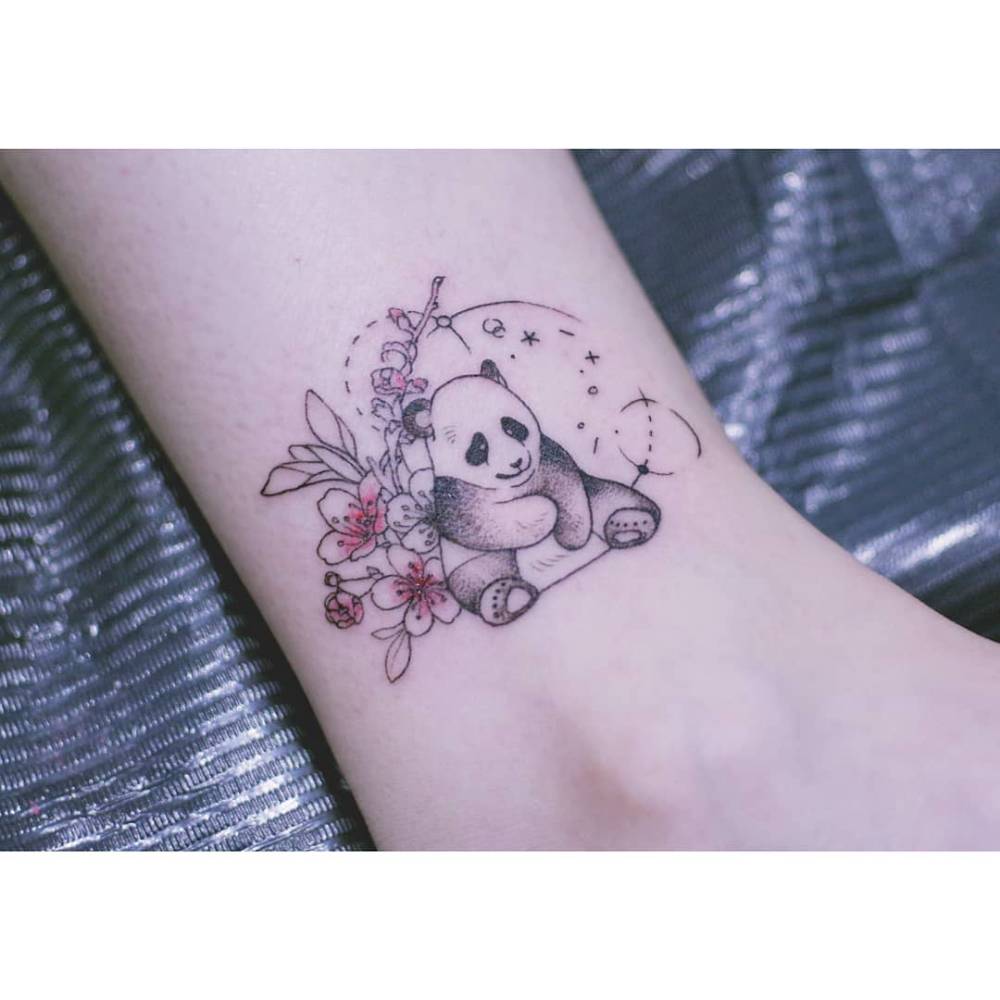 Cartoon style panda and flowers tattoo placed on the ankle.