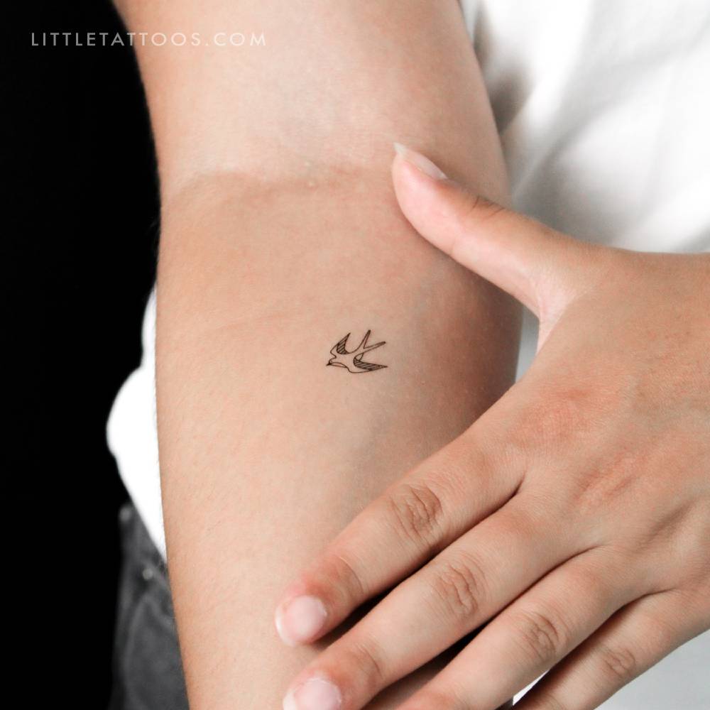 Small fine line swallow temporary tattoo located on the inner forearm.