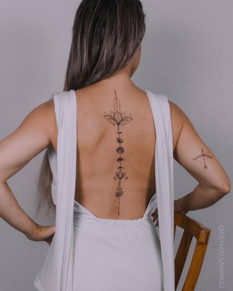 Moon phases tattoo located on the spine.