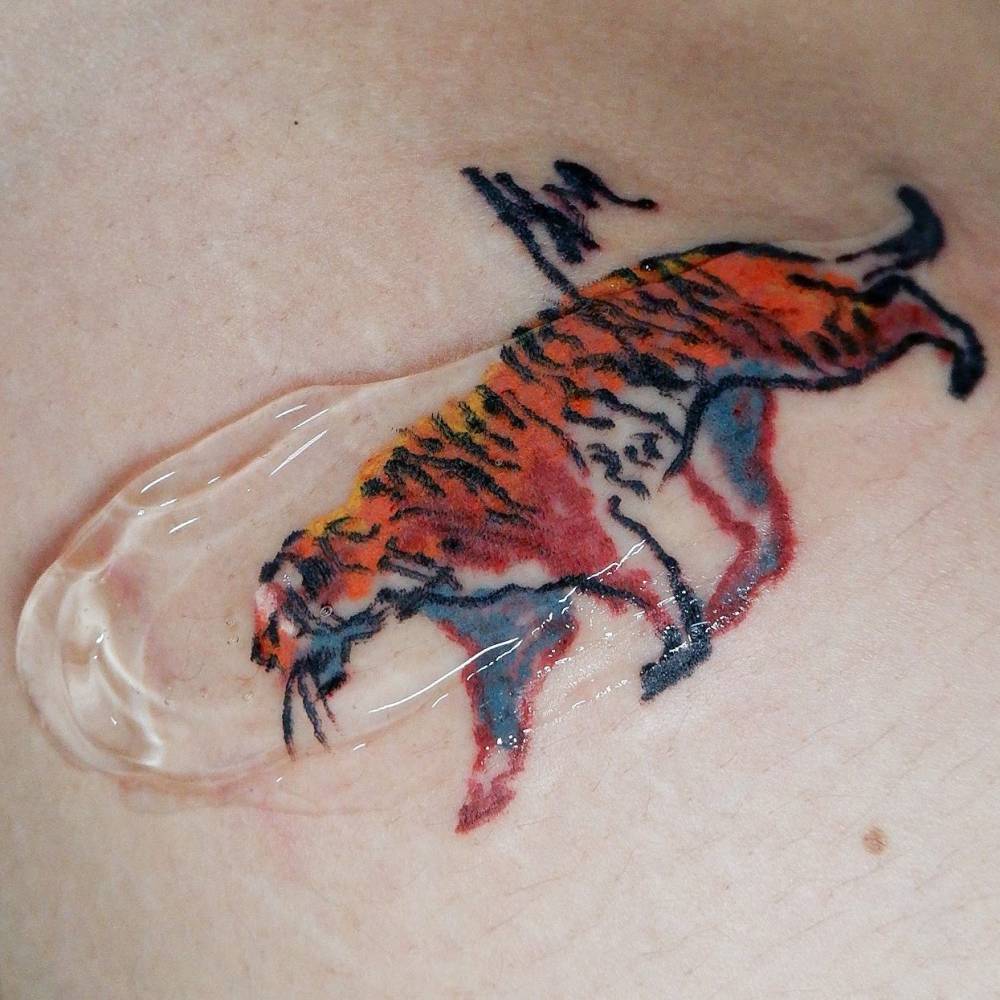 Crayon effect tiger tattoo located on the thigh.