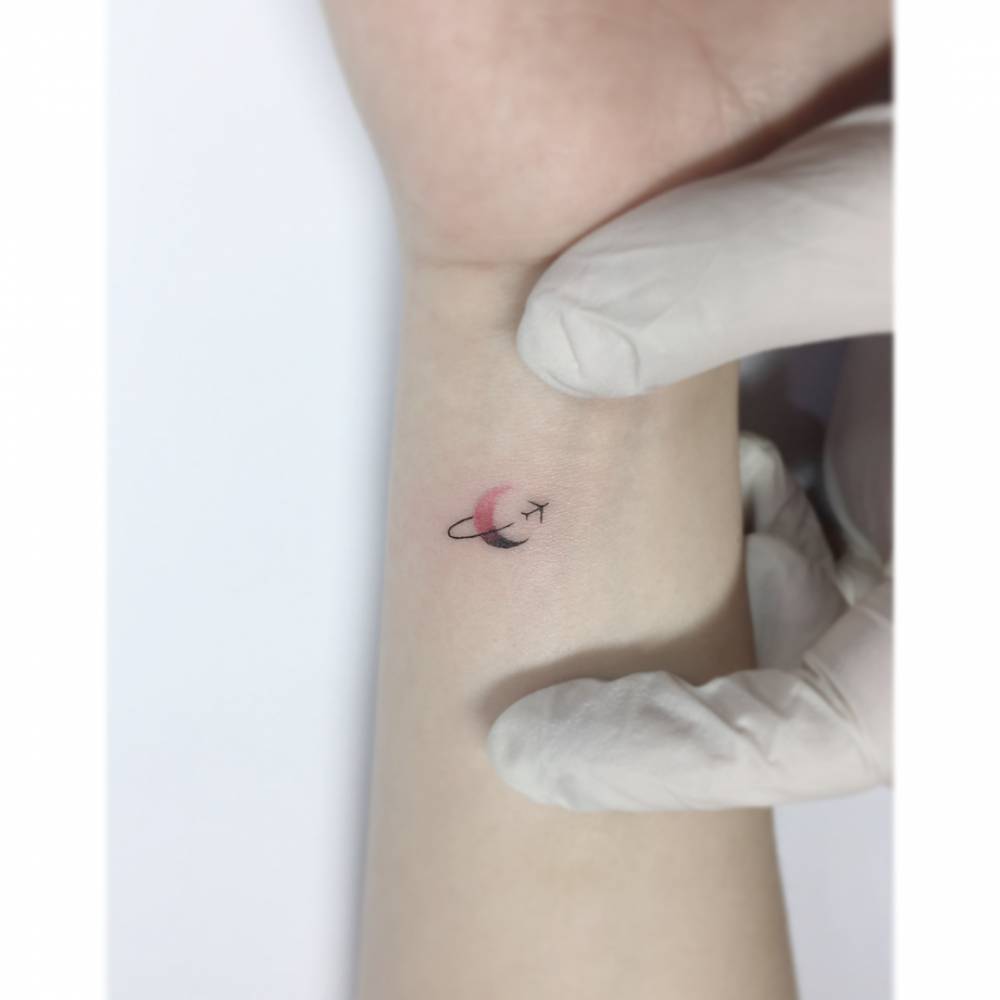 Around the moon tattoo located on the wrist, minimalistic style.