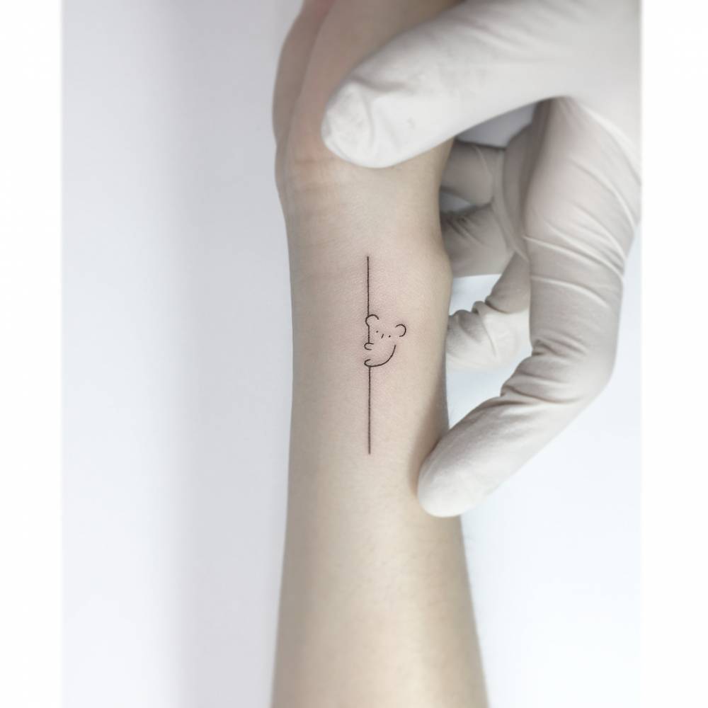 Cute minimalistic koala tattoo located on the wrist.