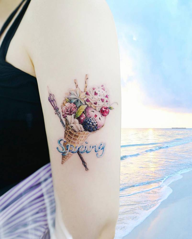 Ice cream X Merci’s Staff (Overwatch) tattooed on the upper arm.