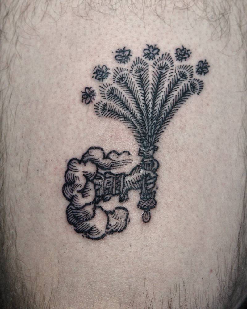 Hand holding flowers tattoo in engraving style located on the thigh.