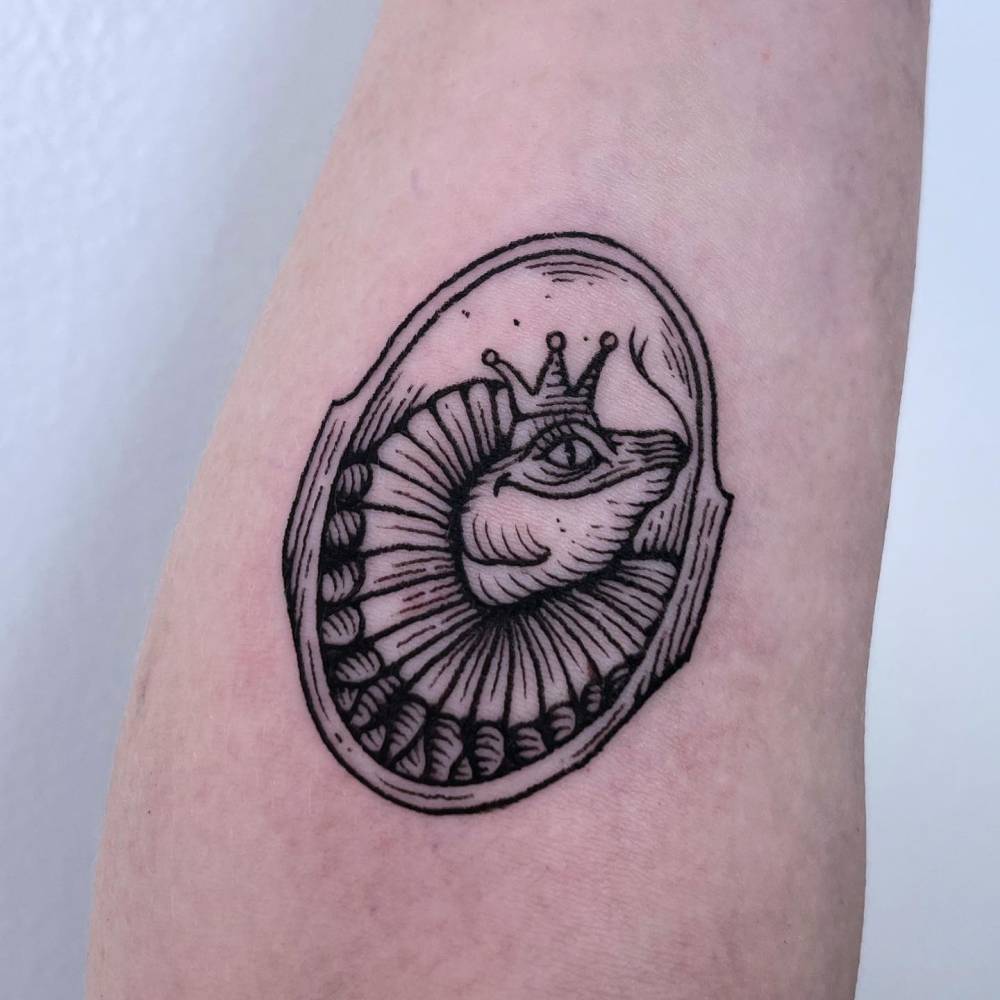 Engraving style nautilus tattoo located on the inner forearm.