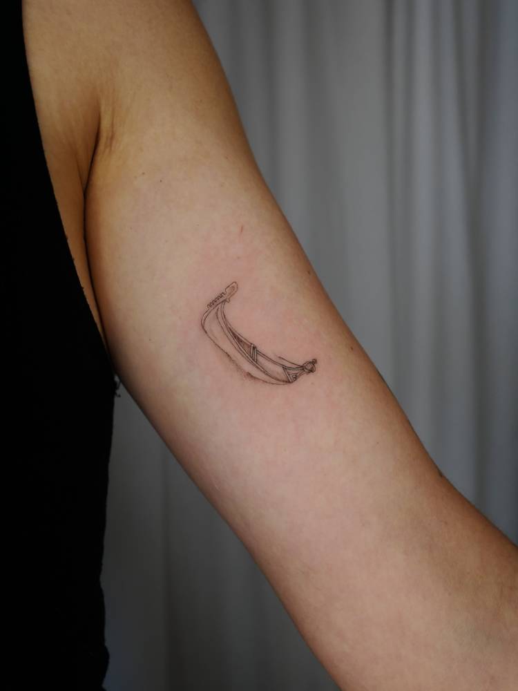 Little boat tattoo located on the inner arm, illustrative style.