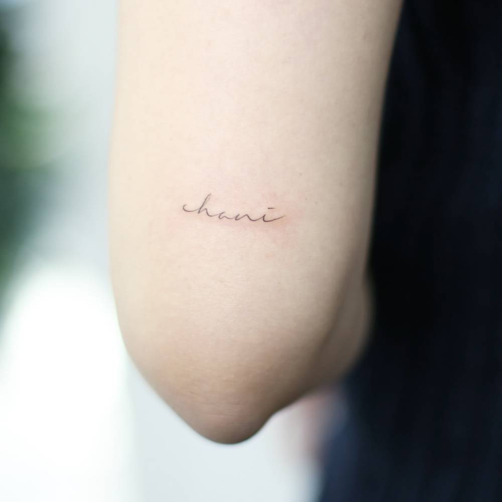 Handwritten font name "Chani" tattooed on the tricep.