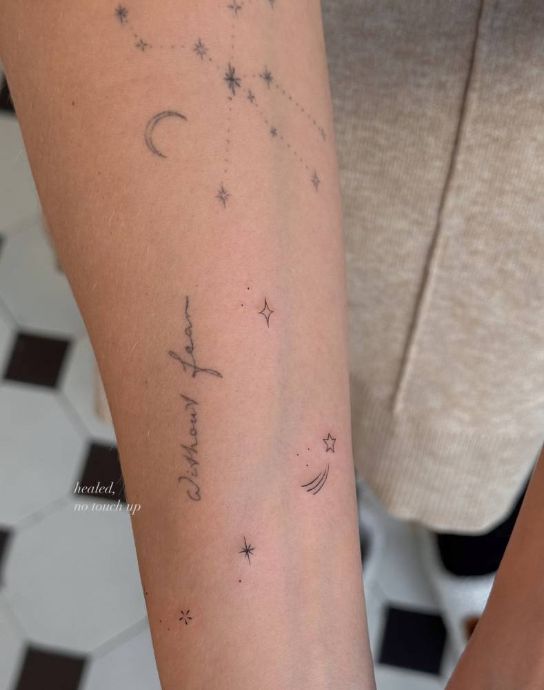 Stars and shooting star tattoo located on the inner forearm.
