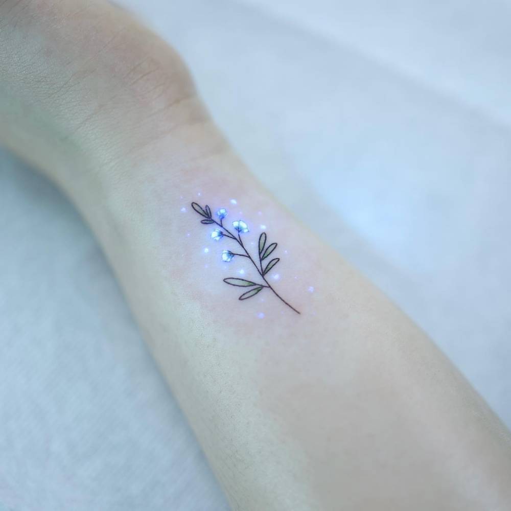 UV ink flower tattoo located on the wrist.