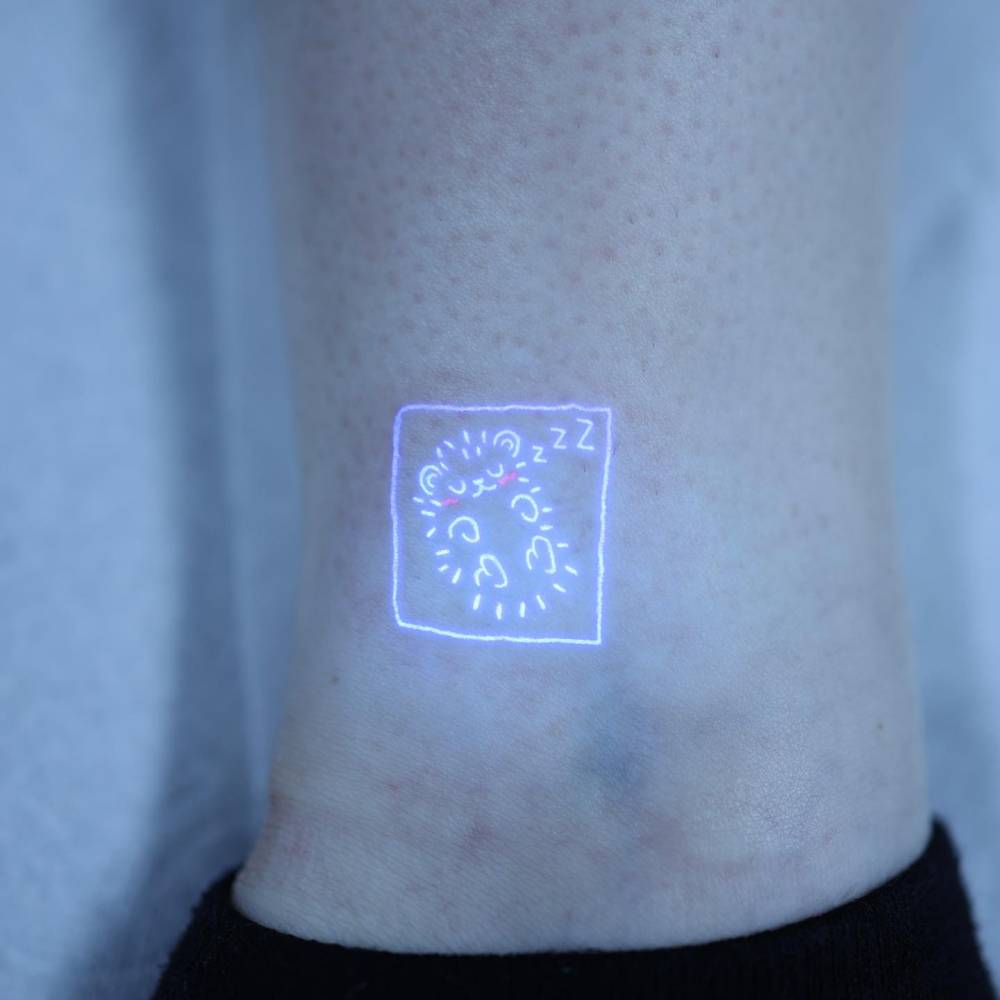 Sleeping hedgehog tattoo in UV ink done on the ankle.