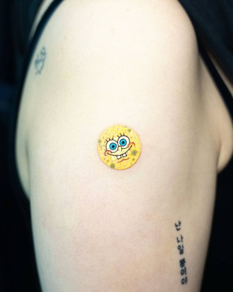 SpongeBob full moon tattoo located on the upper arm, cartoon style.