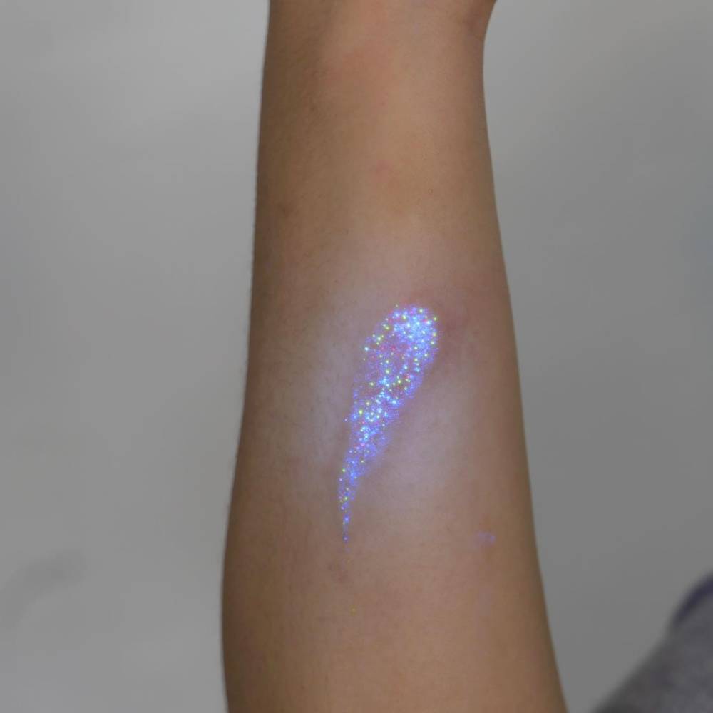 Glitter effect design in UV ink tattooed on the inner forearm.