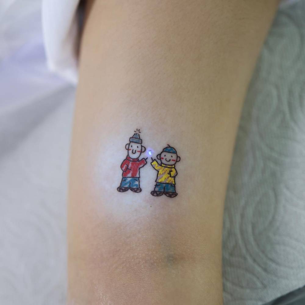 Pat & Mat tattoo located on the bicep, cartoon style.