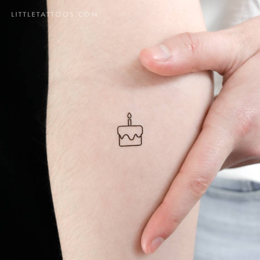 Tiny birthday cake temporary tattoo located on the inner forearm.