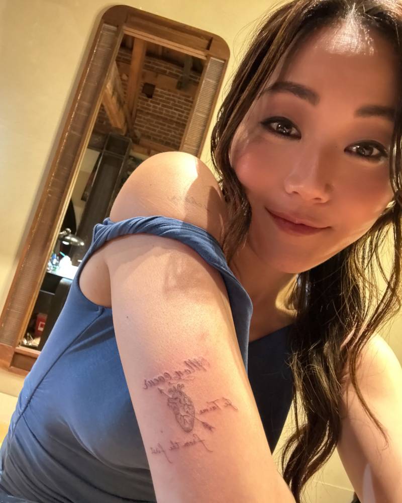 Anatomical heart and arrow tattoo located on Karen Fukuhara's tricep.