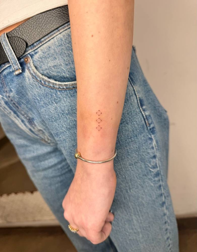 Minimalistic ornamental details tattooed on the wrist.
