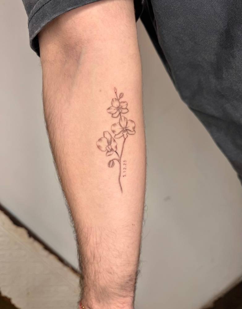 Orchids tattoo in illustrative style placed on the inner forearm.