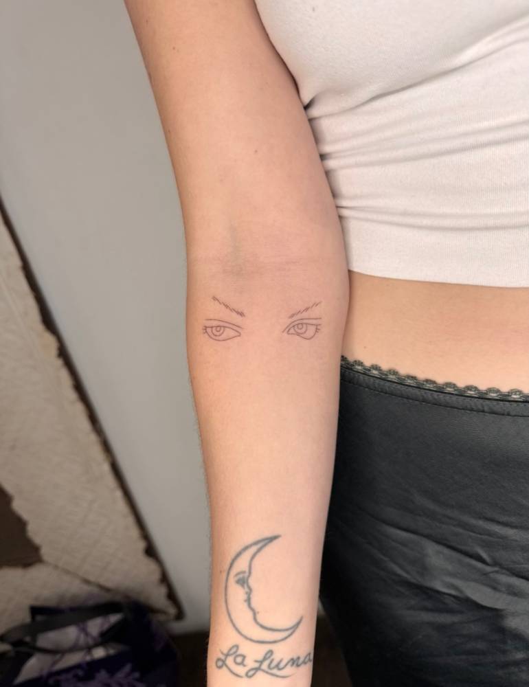 Fine line style eyes tattoo done on the inner forearm.