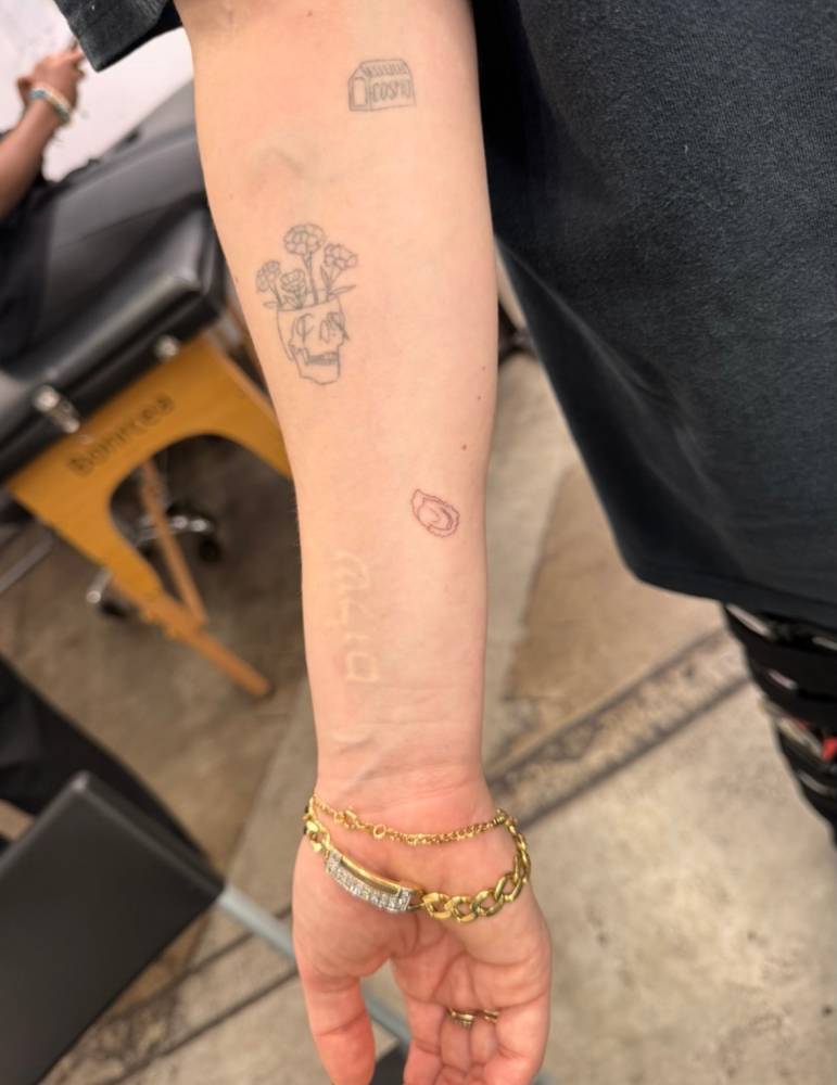 Tiny oyster tattoo in fine line style located on the inner forearm.