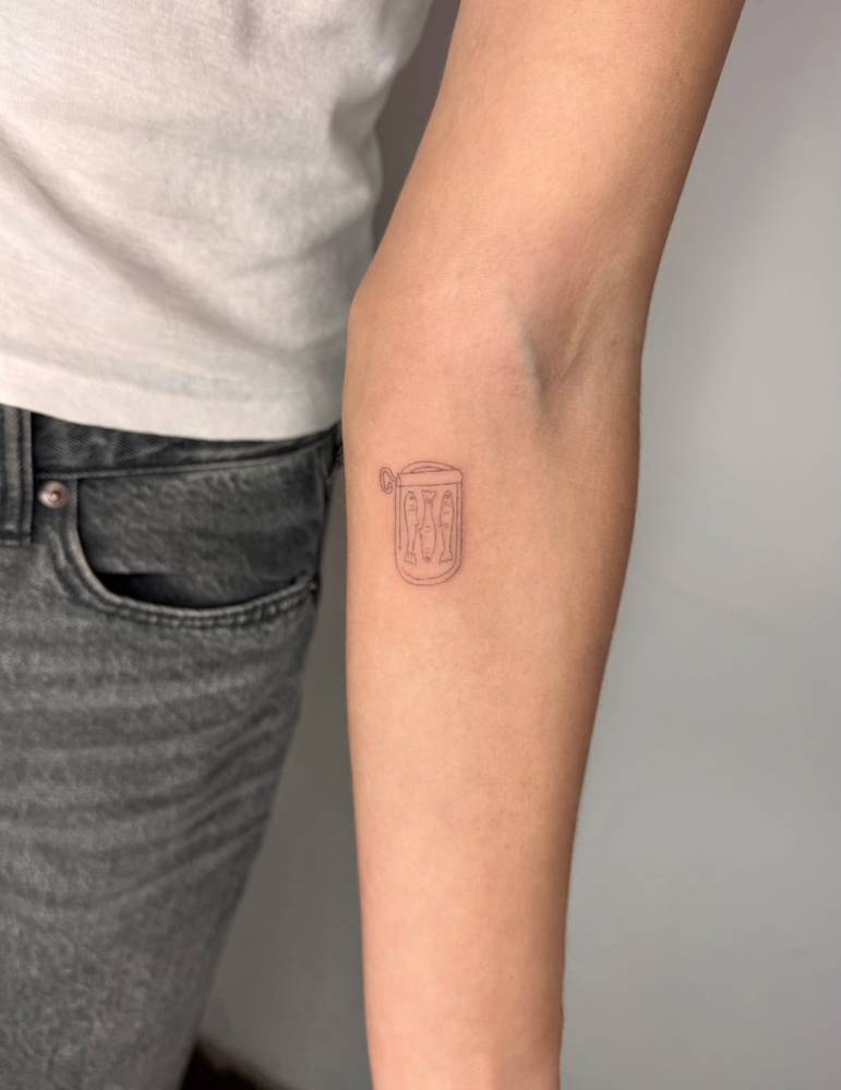 Canned sardines tattoo located on the inner forearm.