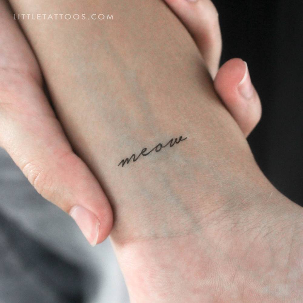 Handwritten font word "meow" temporary tattoo located on the wrist.