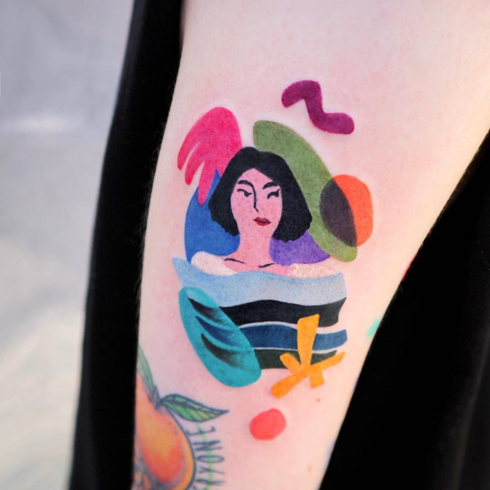 Abstract style woman tattoo located on the uppet arm.