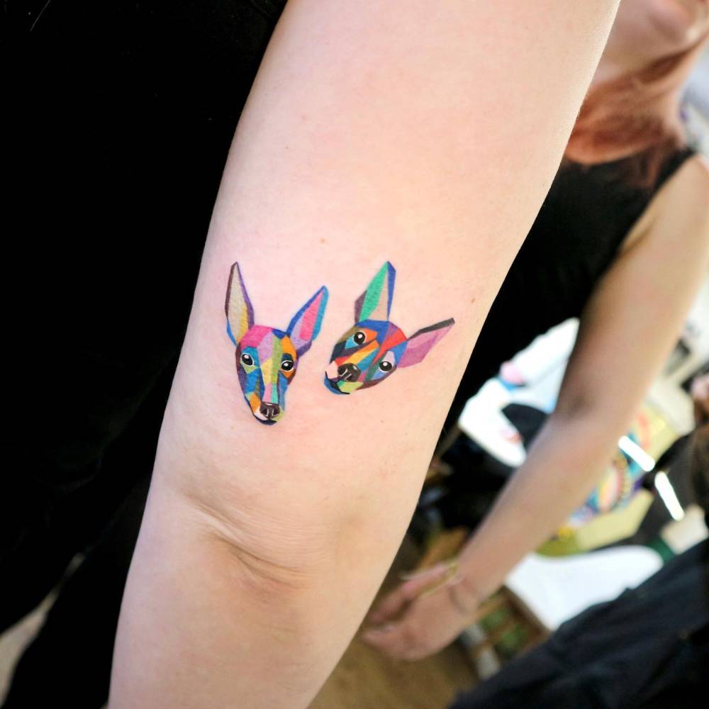 Pop art style dogs portrait tattoo located on the tricep.