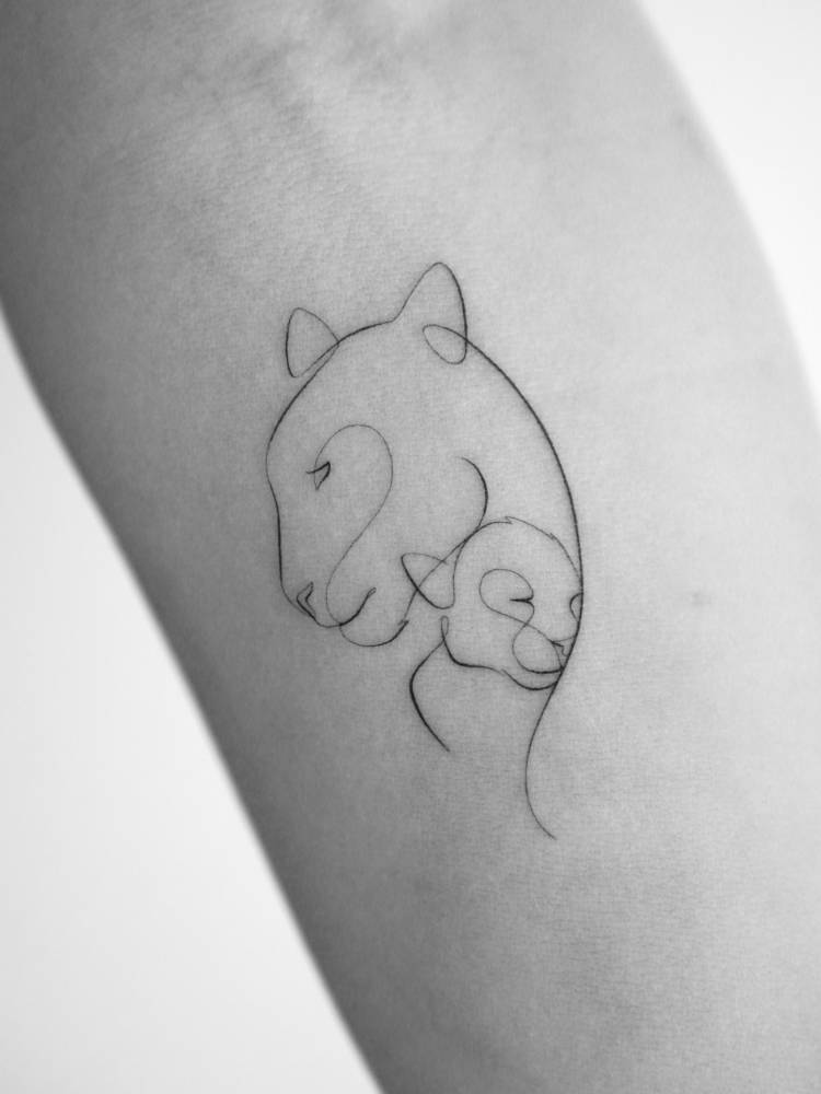 Lioness and cub portrait tattoo located on the inner forearm.