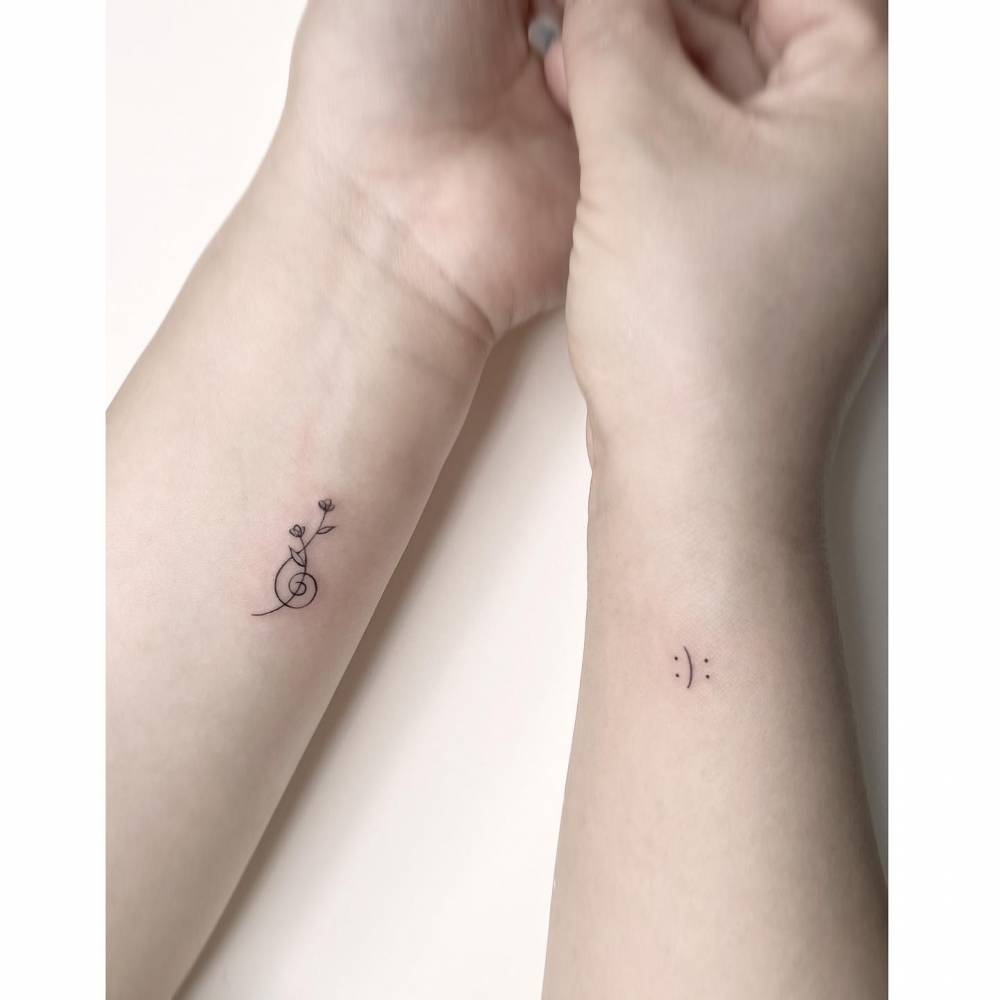 Minimalistic style flowers and happy/sad face tattoos.