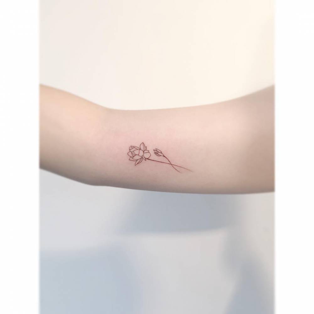 Lotus flower tattoo in fine line style done on the inner arm.