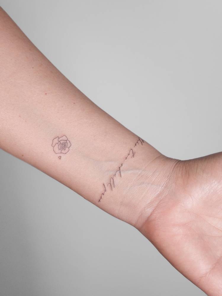 "This too shall pass" and rose head tattooed on the wrist.