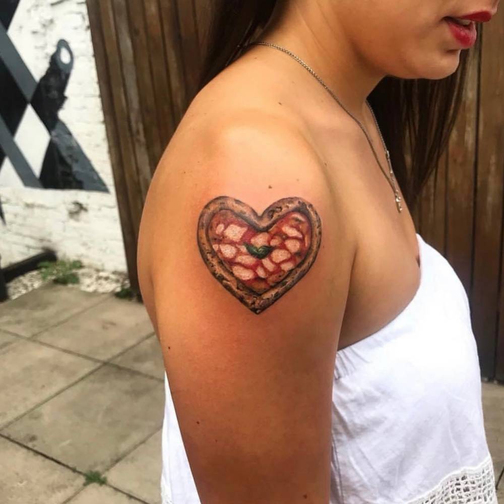 Micro-realistic style Margherita heart pizza tattoo located on the shoulder.
