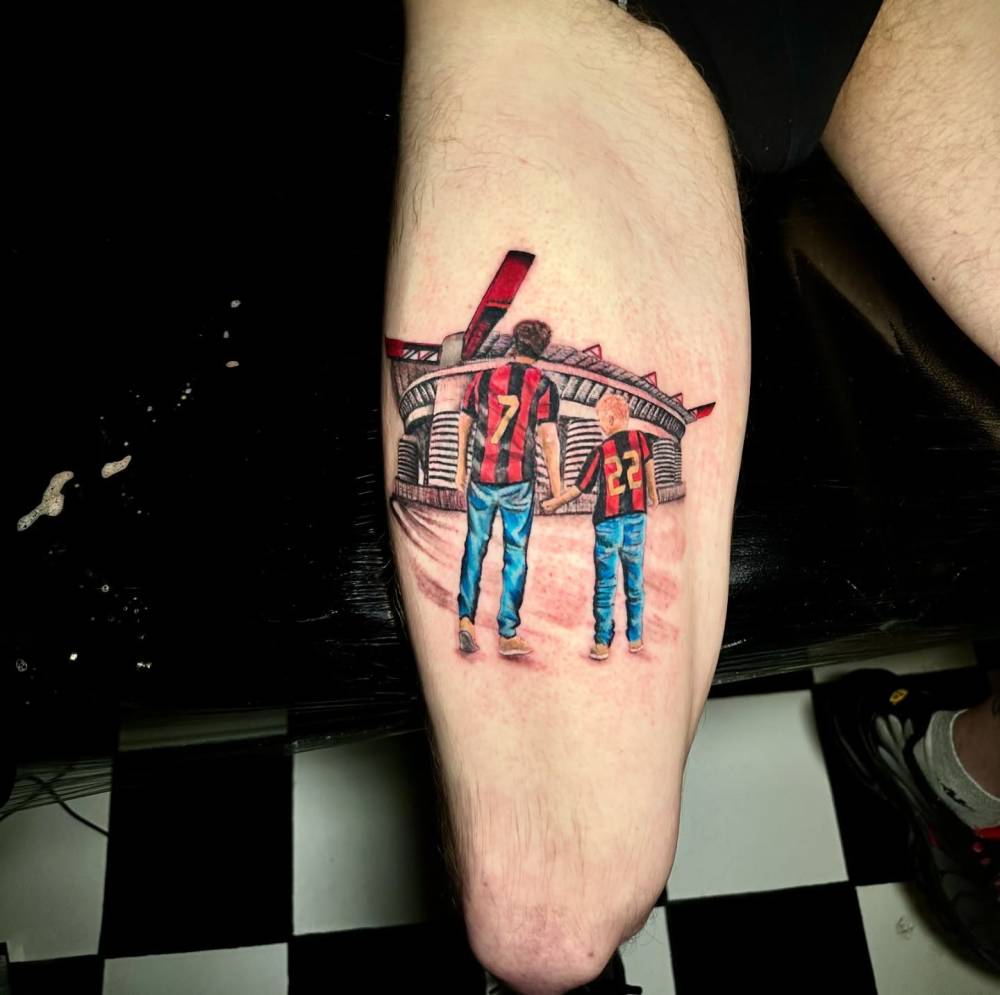 AC Milan tattoo located on the thigh, done in illustrative style.
