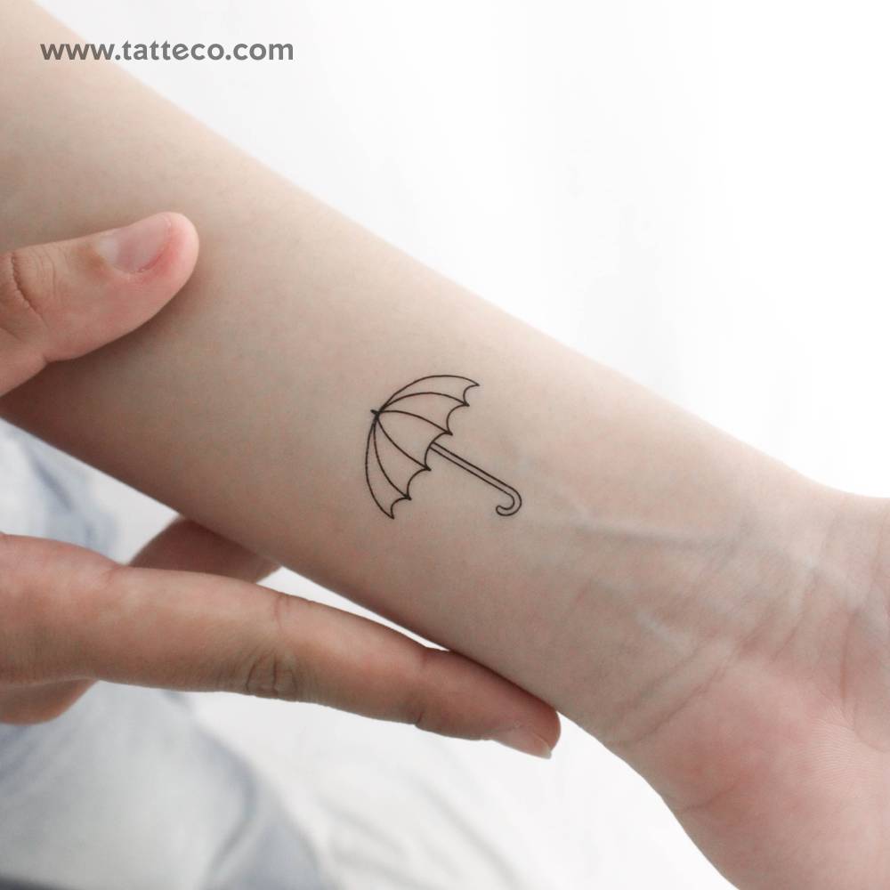 Umbrella temporary tattoo in fine line style located on the wrist.
