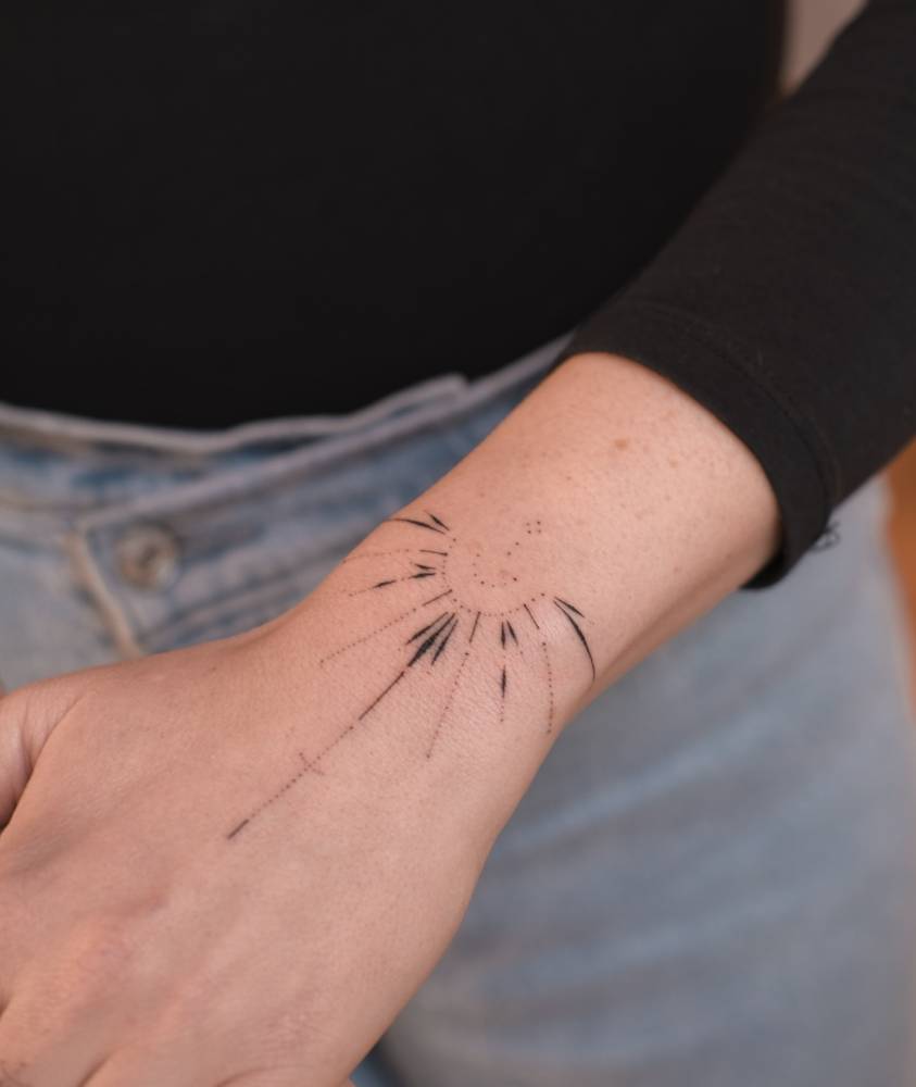 Hand poked ornamental tattoo located on the wrist.