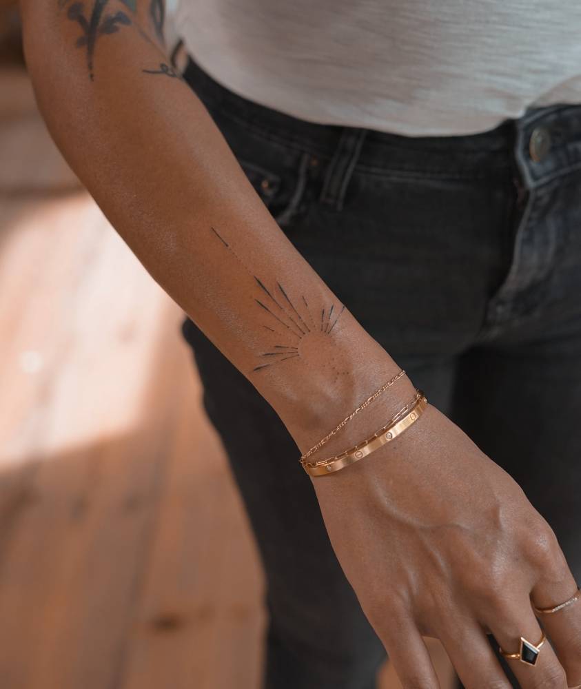 Hand poked style ornamental design tattooed on the wrist.