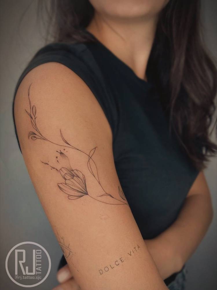 Tulip flower tattoo in illustrative style done on the upper arm.