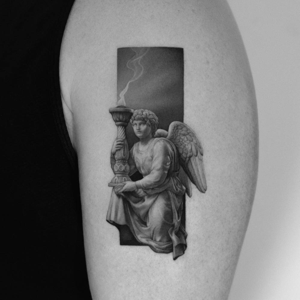 Angel (Michelangelo) tattooed on the upper arm, micro-realistic style.