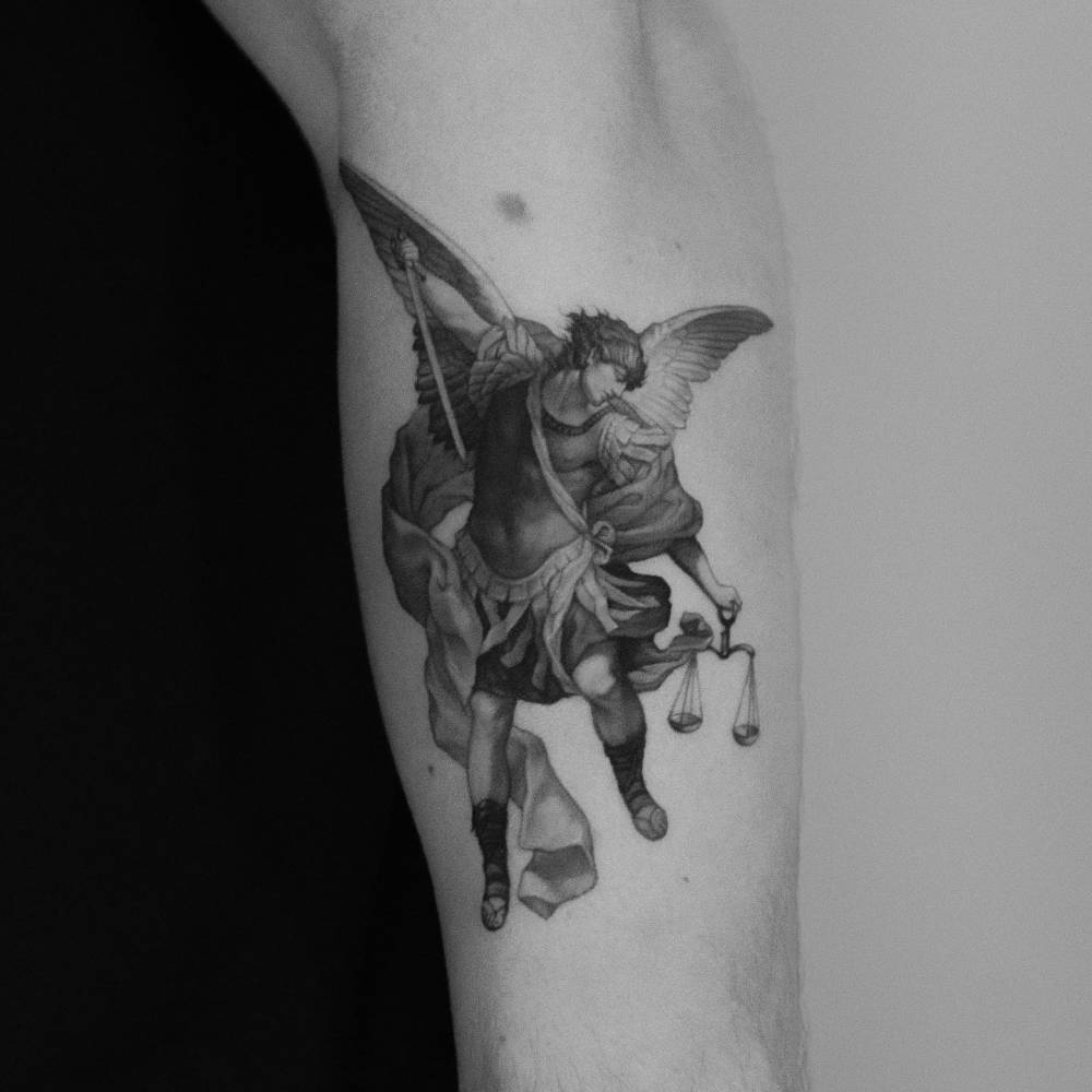 Classical style 'Archangel Michael Defeating Satan' tattoo located on the forearm.