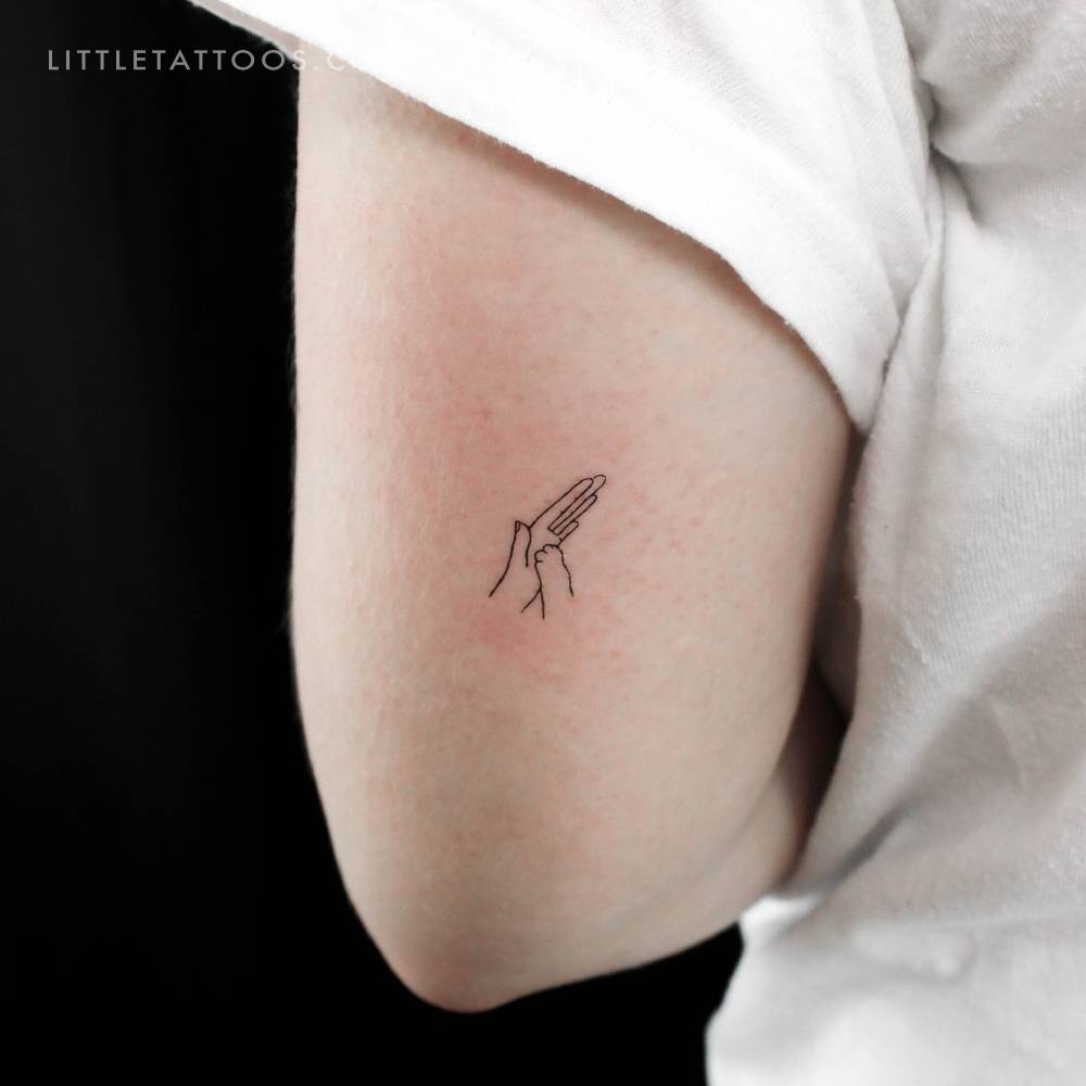 Dog high five temporary tattoo located on the tricep.