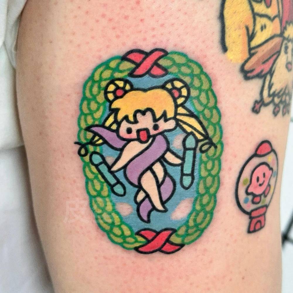 The World Tarot Card tattoo in cartoon style located on the thigh.