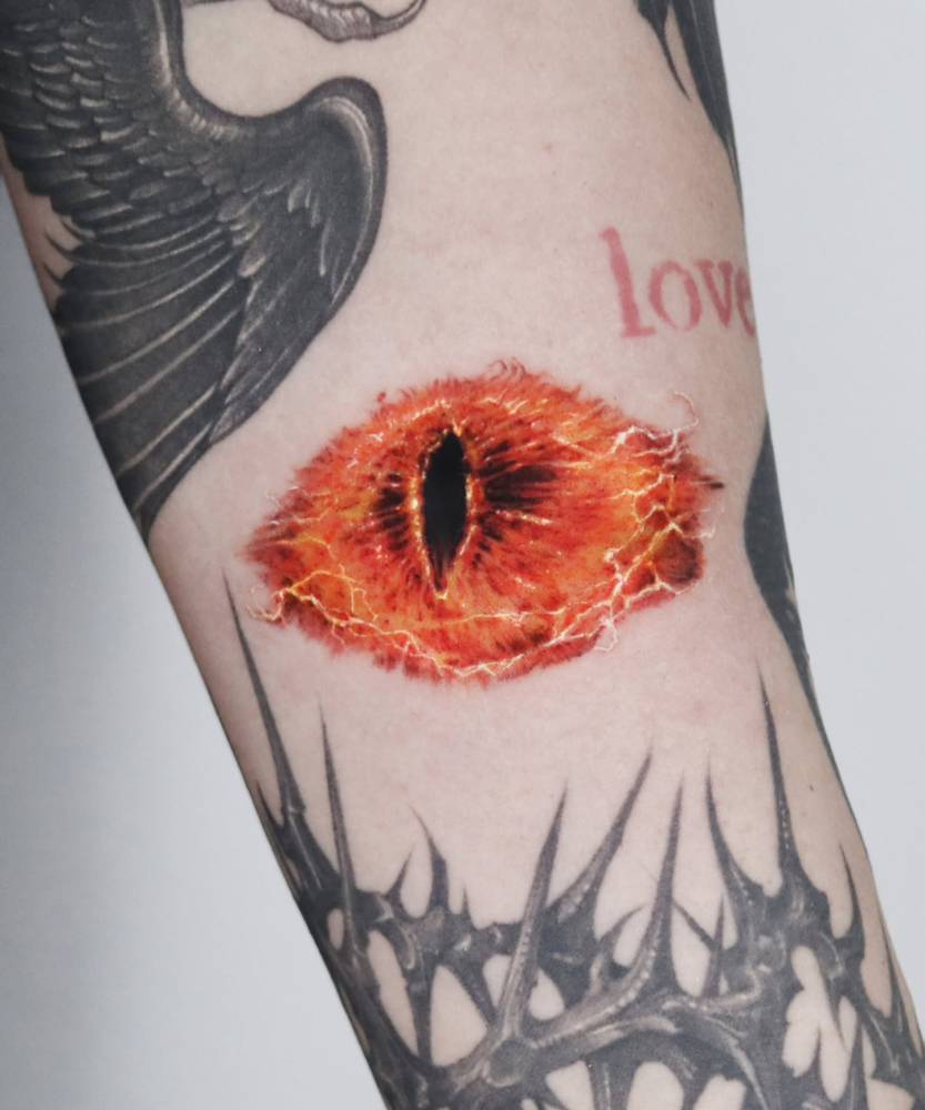 Eye of Sauron tattoo in micro-realistic style done on the inner forearm.
