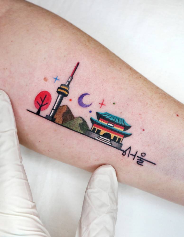 Pop art style Seoul skyline tattoo placed on the inner forearm.