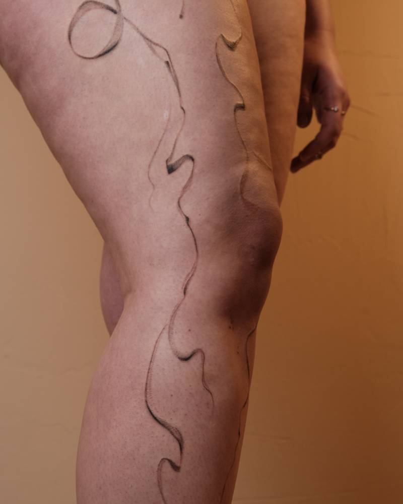 Abstract flow tattoo located on the leg.