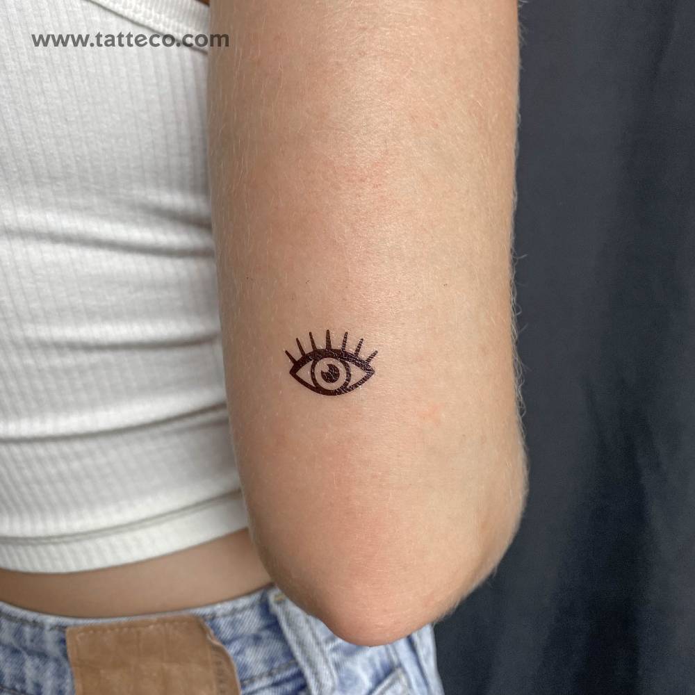Minimalistic style evil eye temporary tattoo located on the tricep.